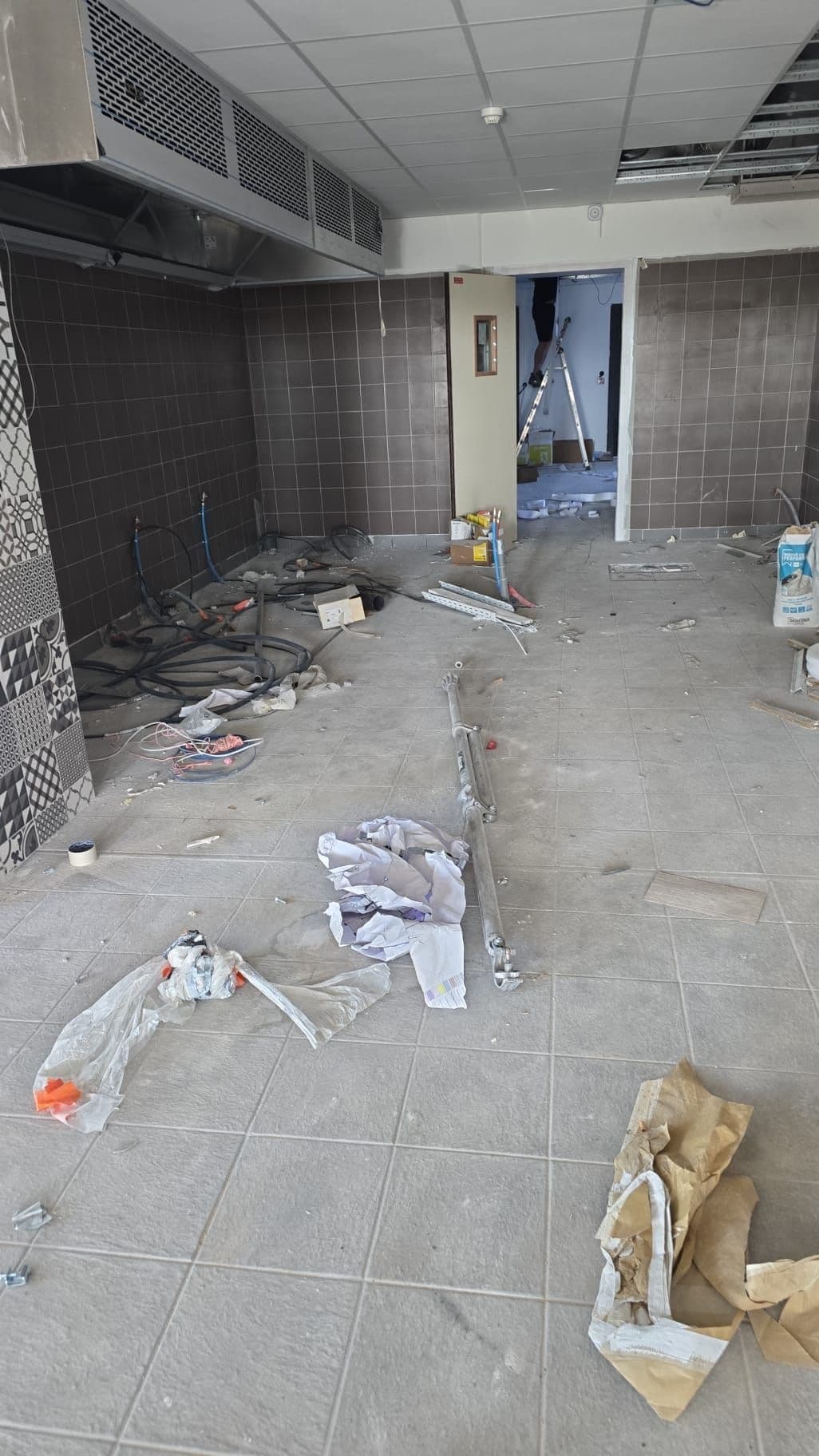 Cuisine d'un local commercial en fin de travaux, gravats et emballages au sol