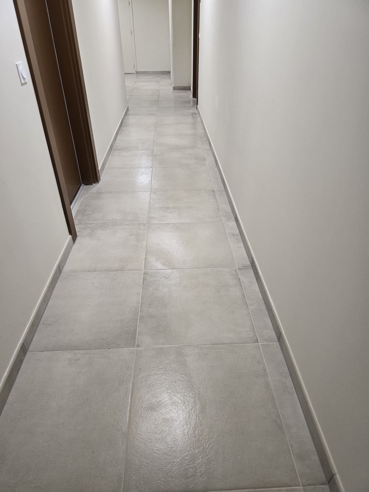 Couloir de distribution au carrelage clair remis en état