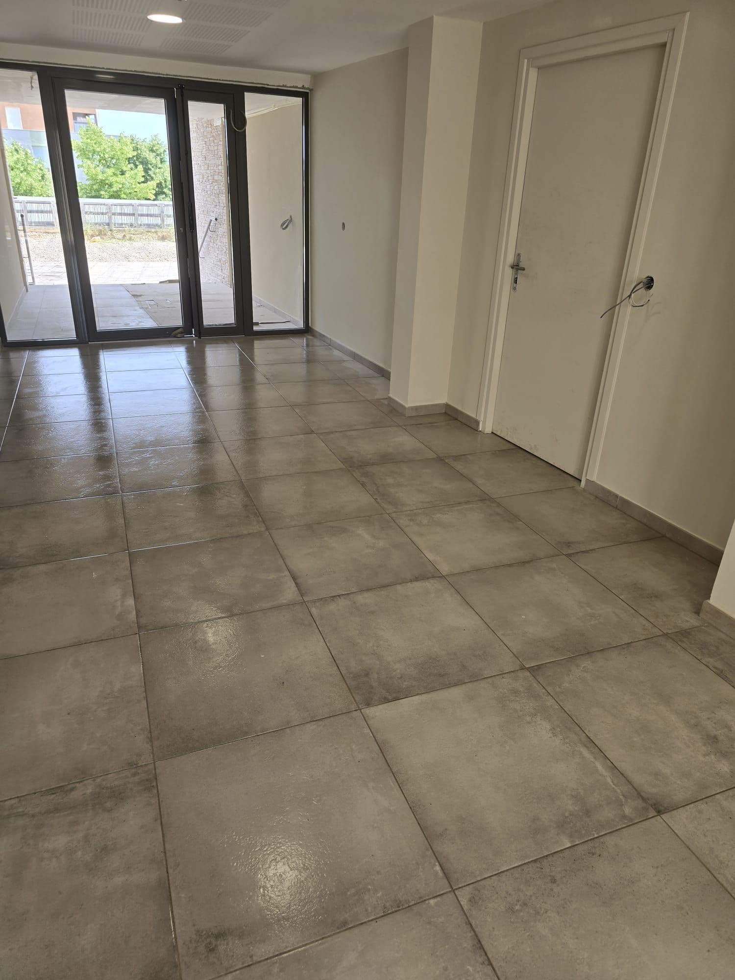 Entrée d'appartement, carrelage repris jusqu'aux plinthes